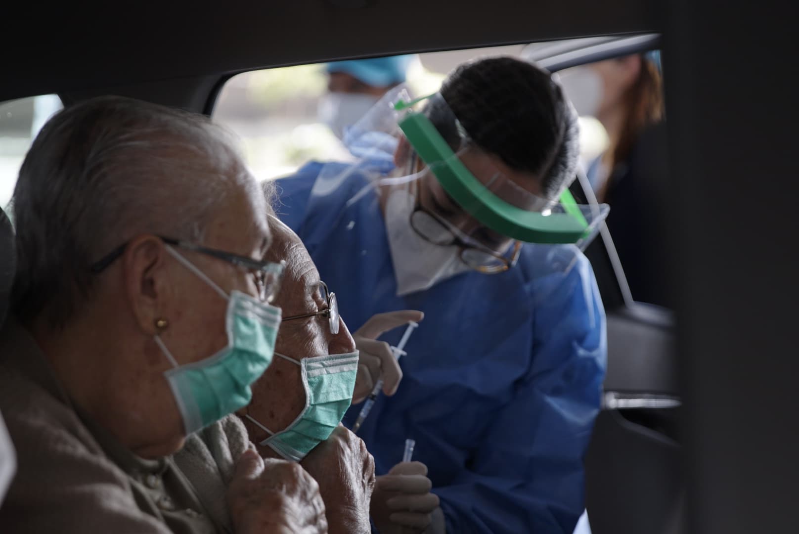 Aplican vacuna a adulto mayor en vehículo