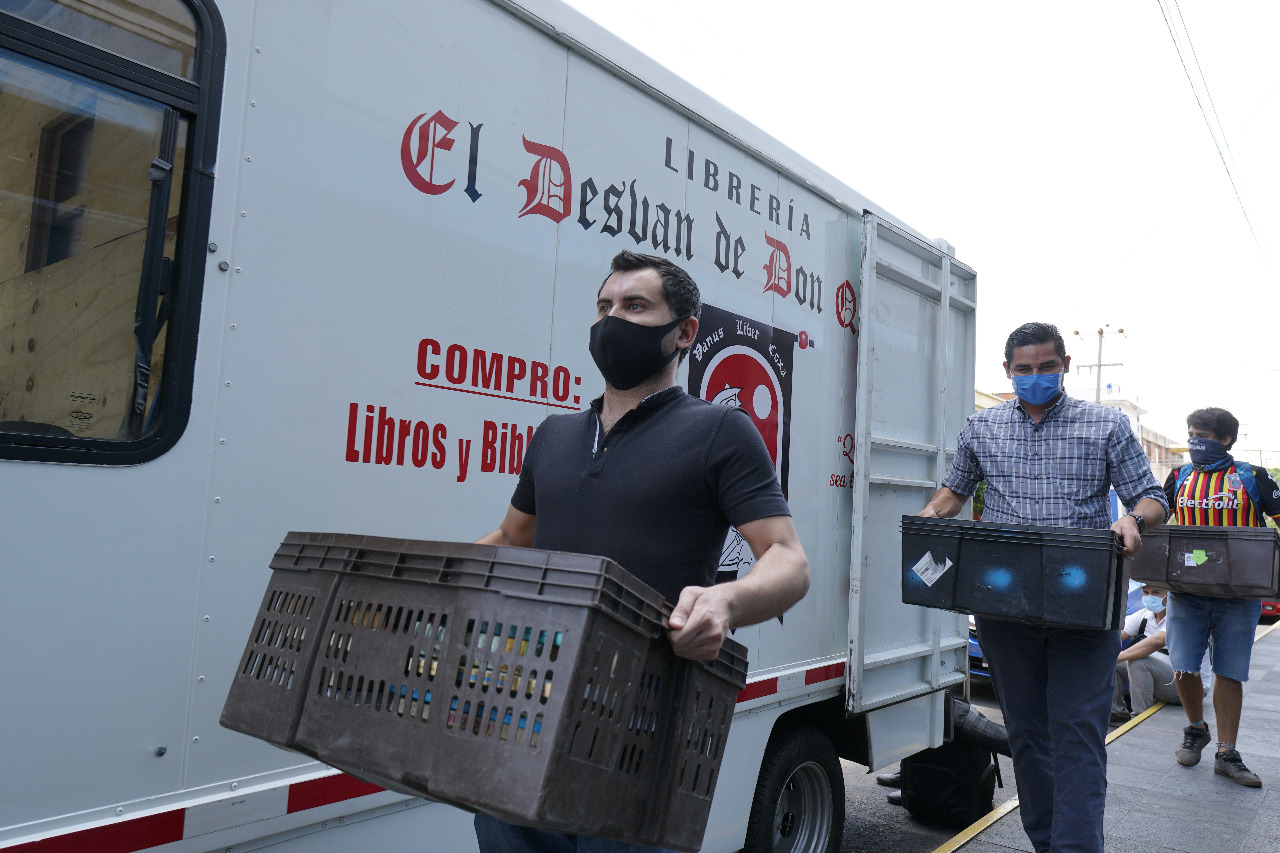 Personas cargando cajas de libros