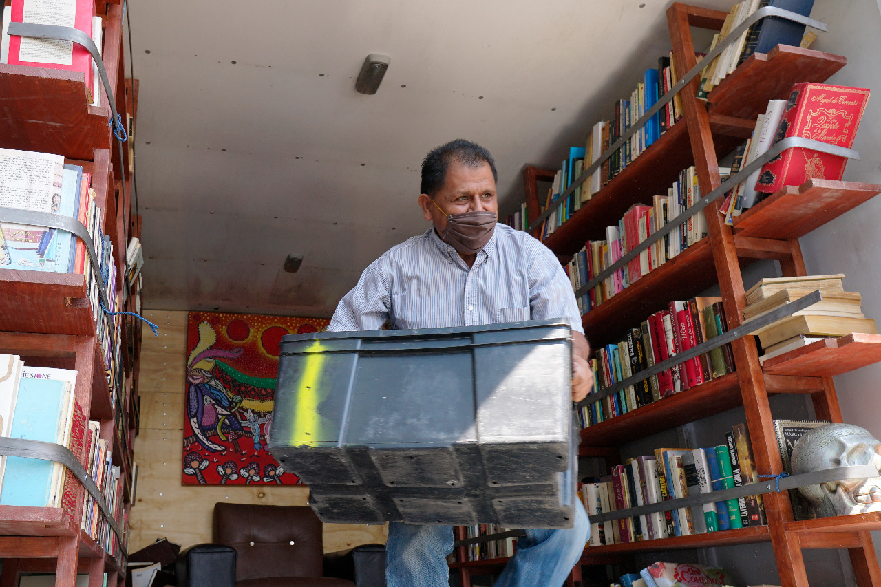 Persona cargando cajas de libros