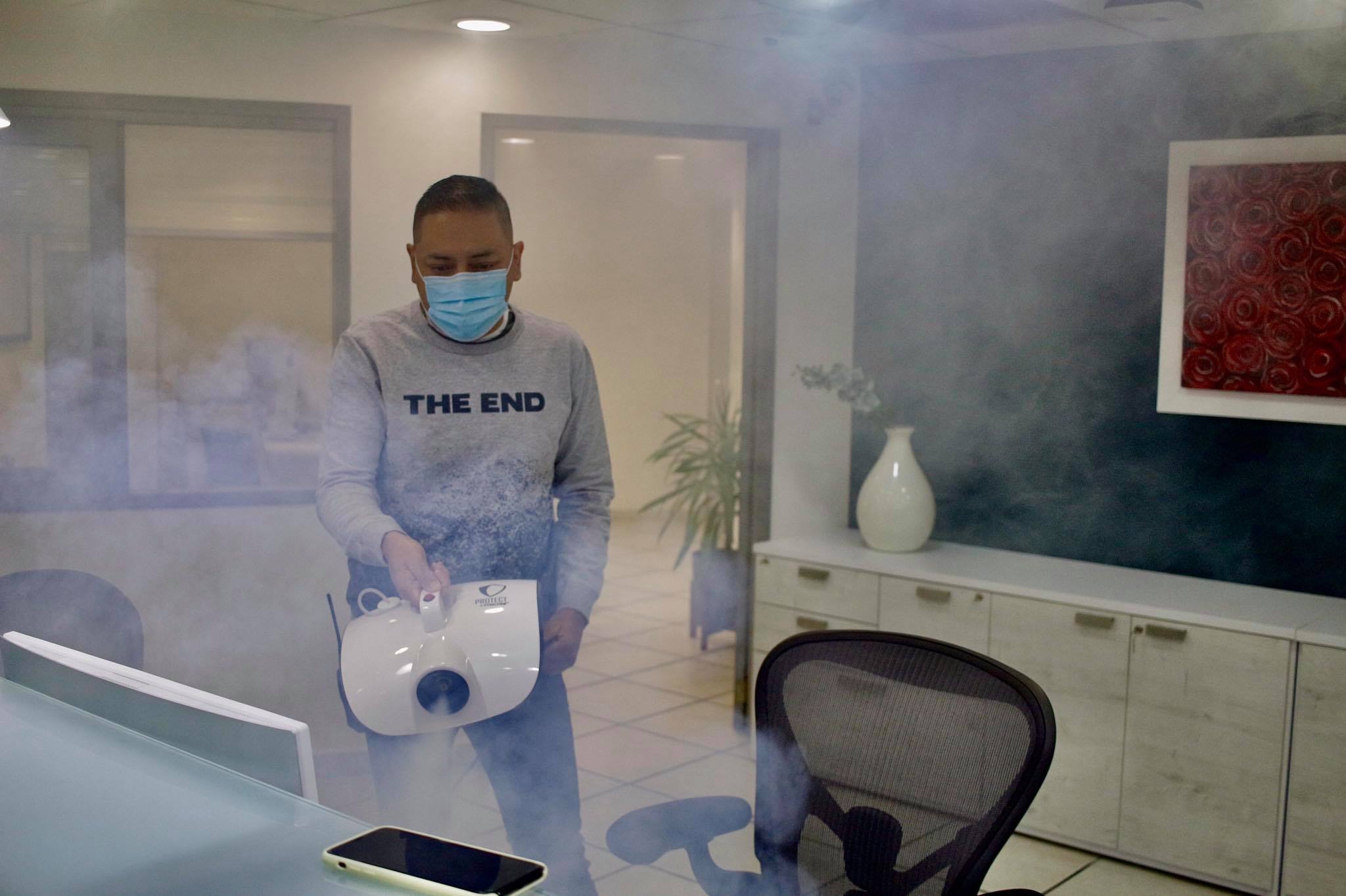 Persona realiza sanitización de espacios