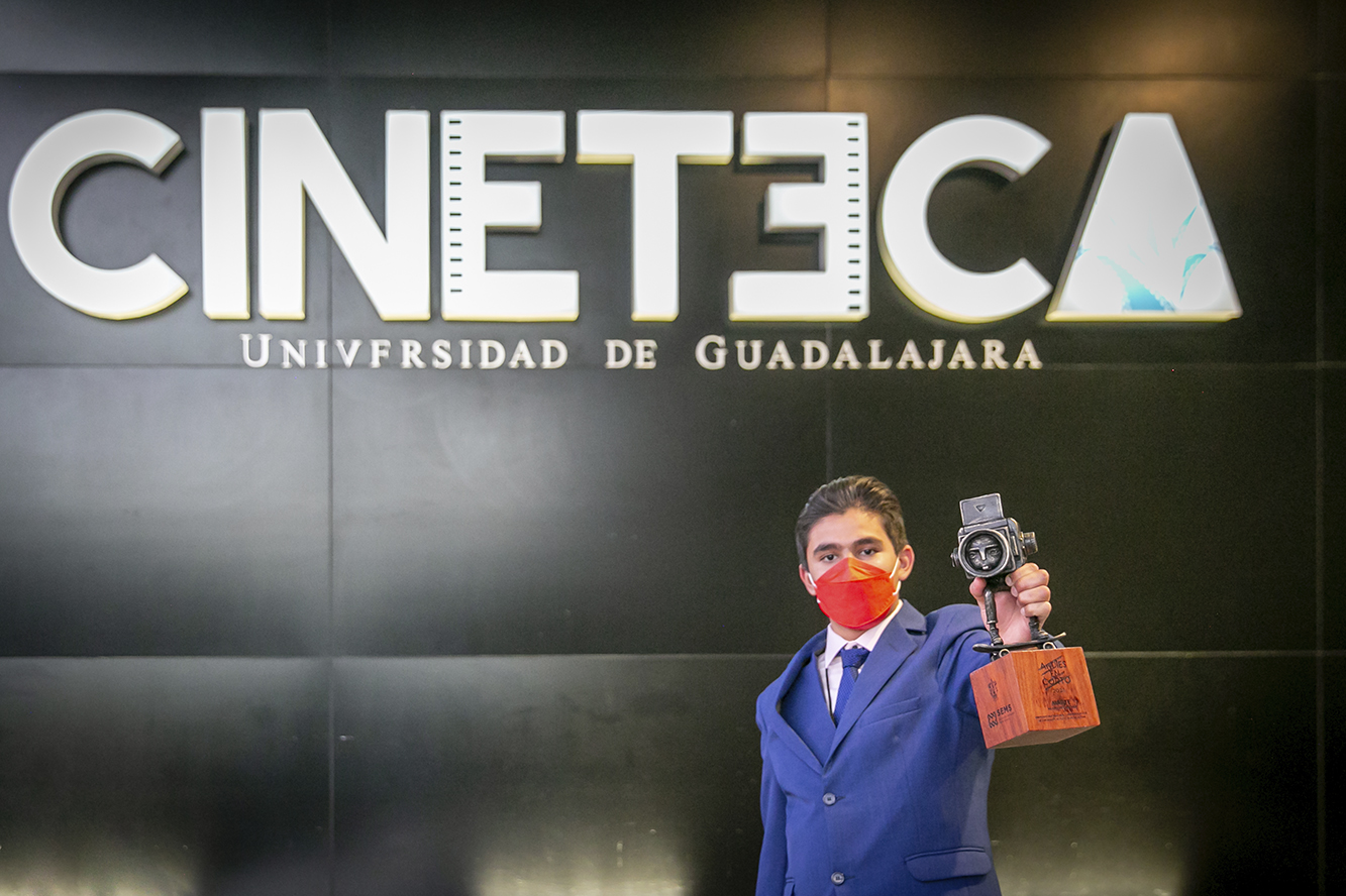 Ganador de concurso mostrando la estatuilla de premio