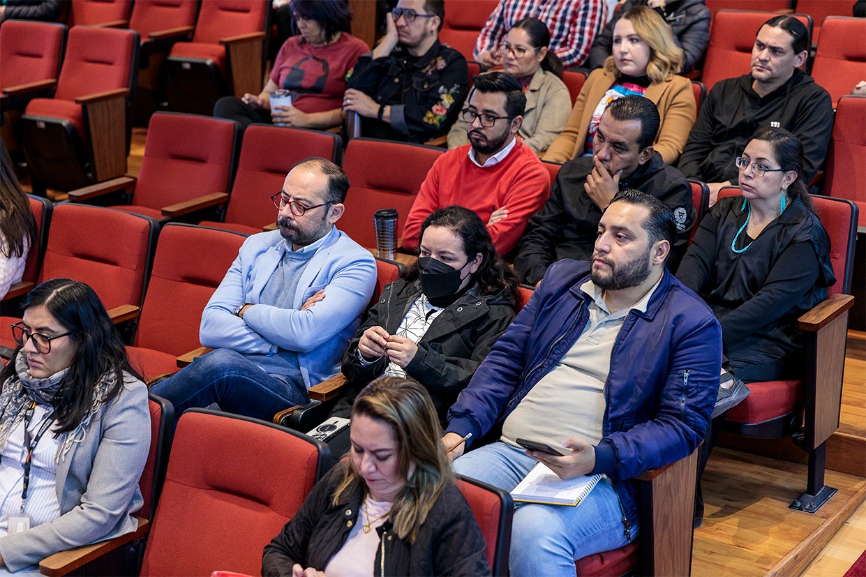 asistentes al evento sentados en auditorio