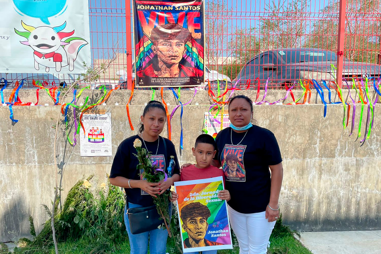 Dos mjeres y un niño con cartel en sus manos de Jonathan Santos quién fuera asesinado