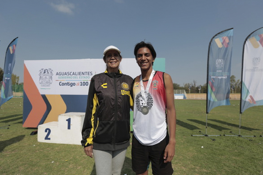 Atleta con medalla junto a su entrenadora