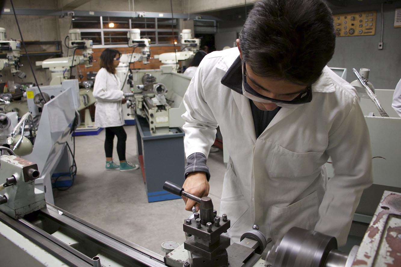 Alumnos operando un torno