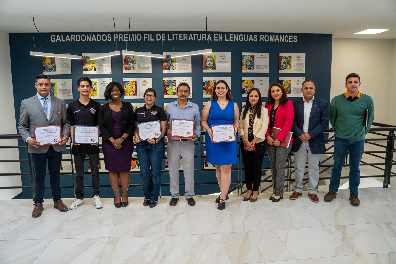 Autoridades del evento de pie junto a alumnos que recibieron reconocimiento del consulado de estados unidos