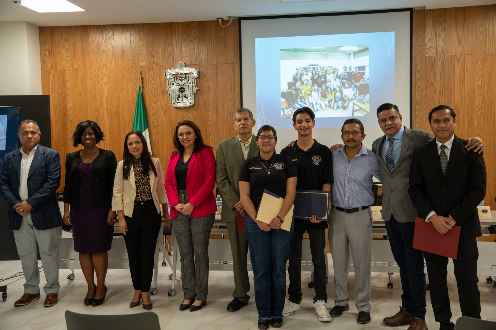 Autoridades del evento de pie junto a alumnos que recibieron reconocimiento del consulado de estados unidos