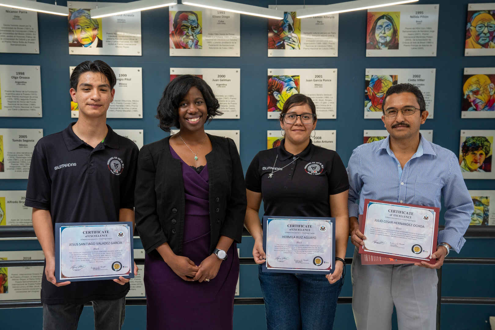 Autoridades del evento de pie junto a alumnos que recibieron reconocimiento del consulado de estados unidos