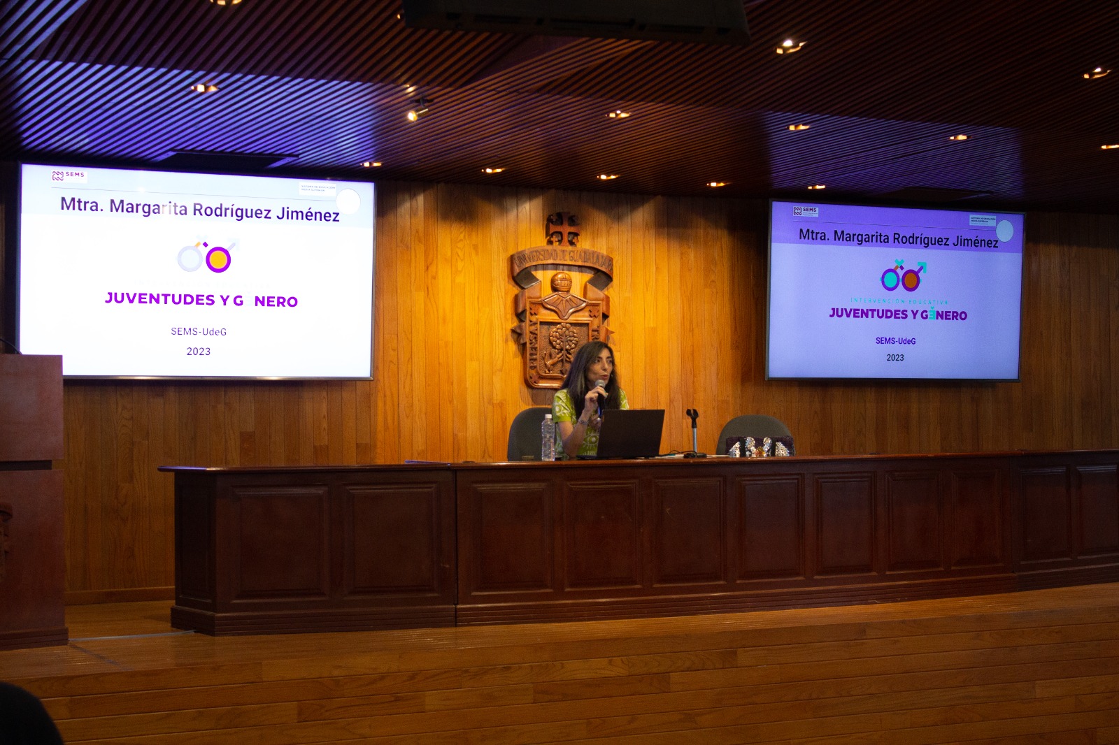 maestra Margarita Rodríguez en presidium frente a asistentes