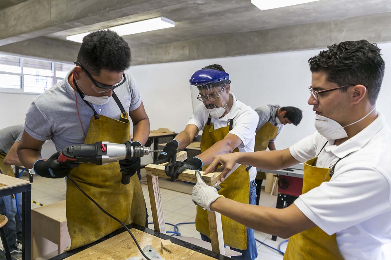 Alumnos trabajan con maquinas