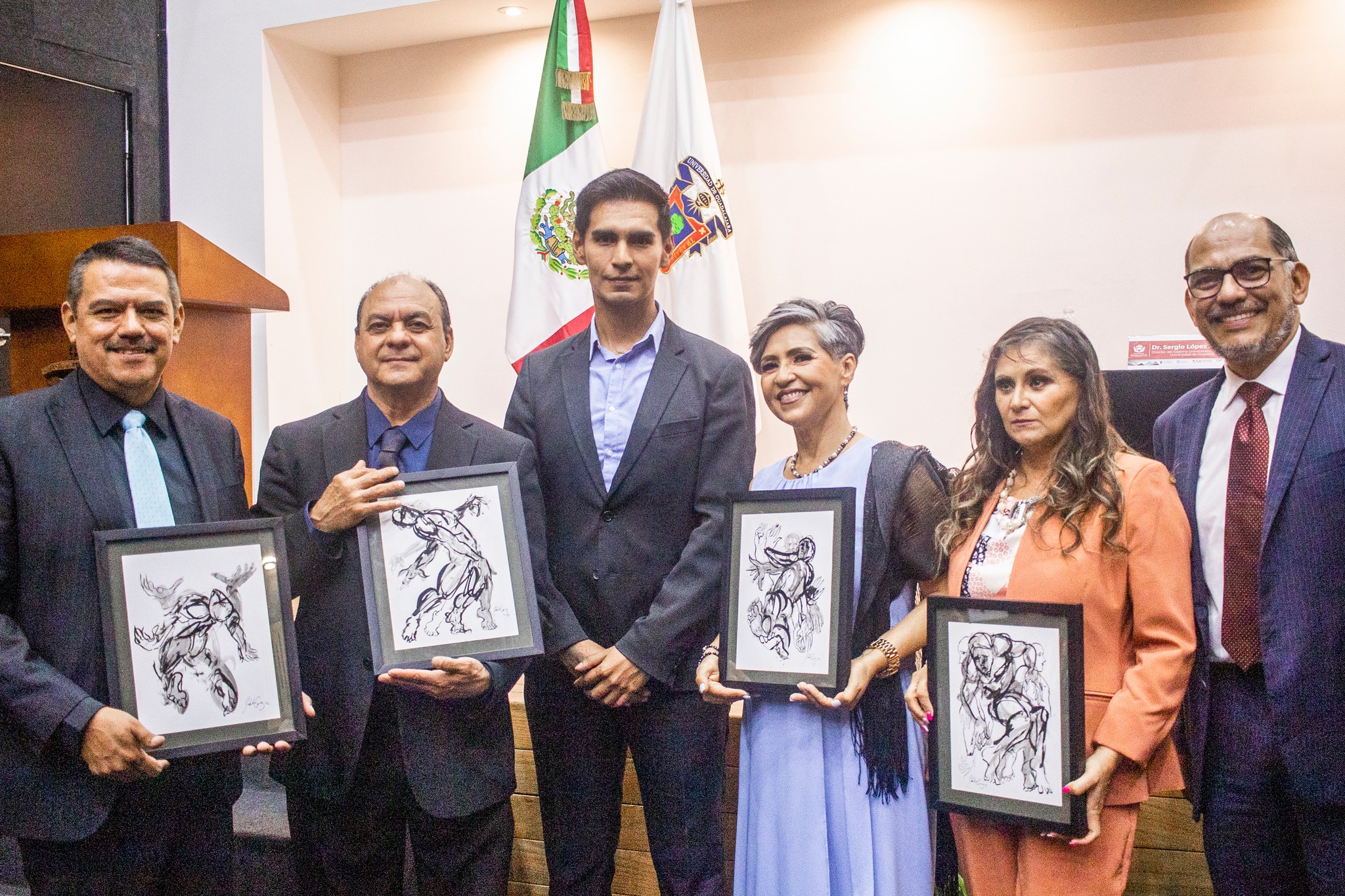 Bibliotecarios reconocidos junto a autoridades del evento en auditorio frente a asistentes