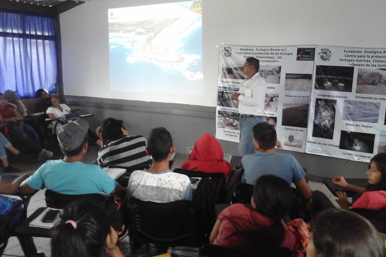 Expositor en charla con alumnos en aula 
