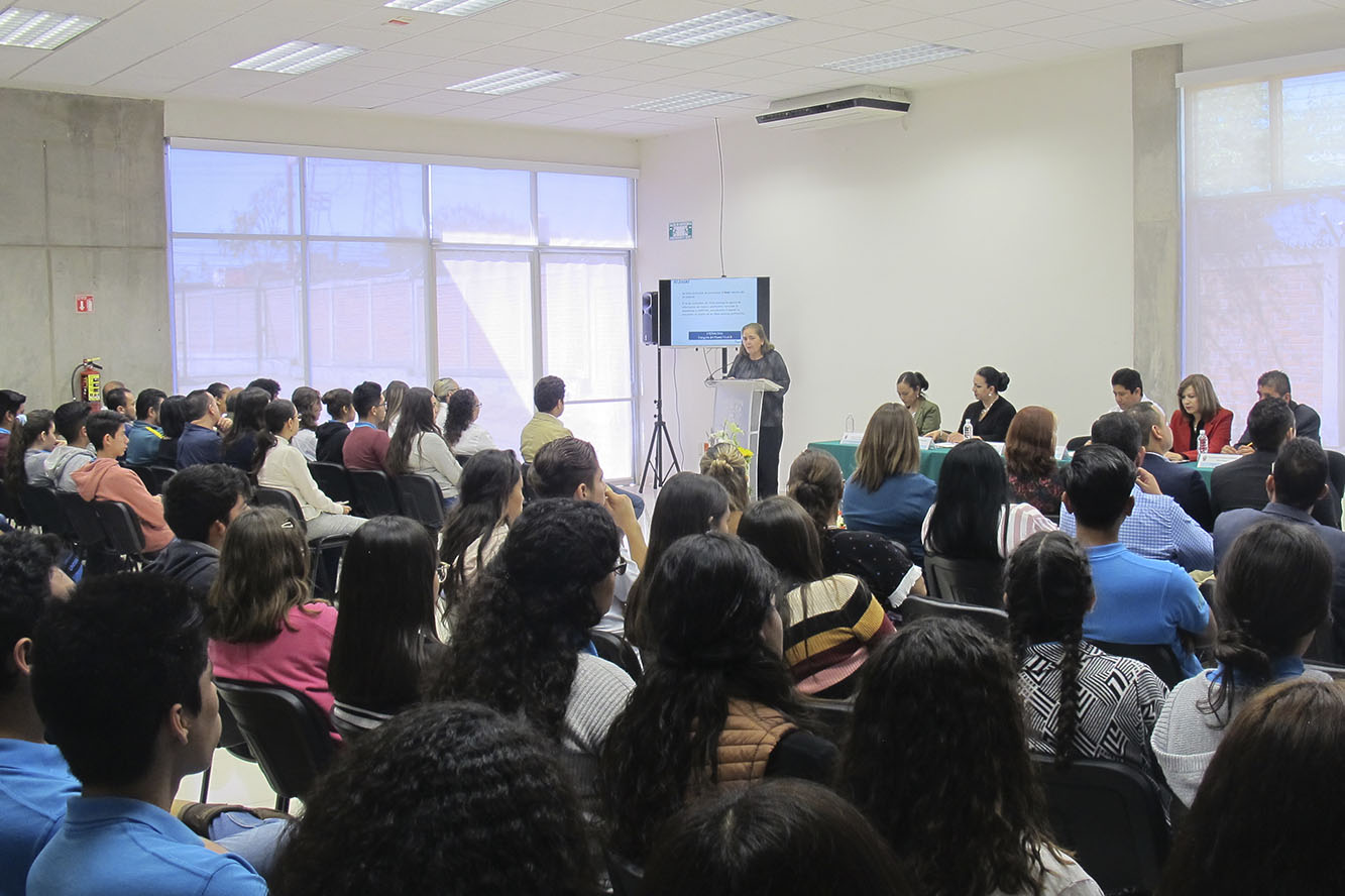 Directora en auditorio frente a asistentes