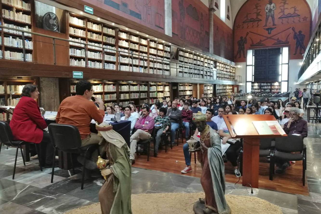 Expositor en biblioteca frente a asistentes