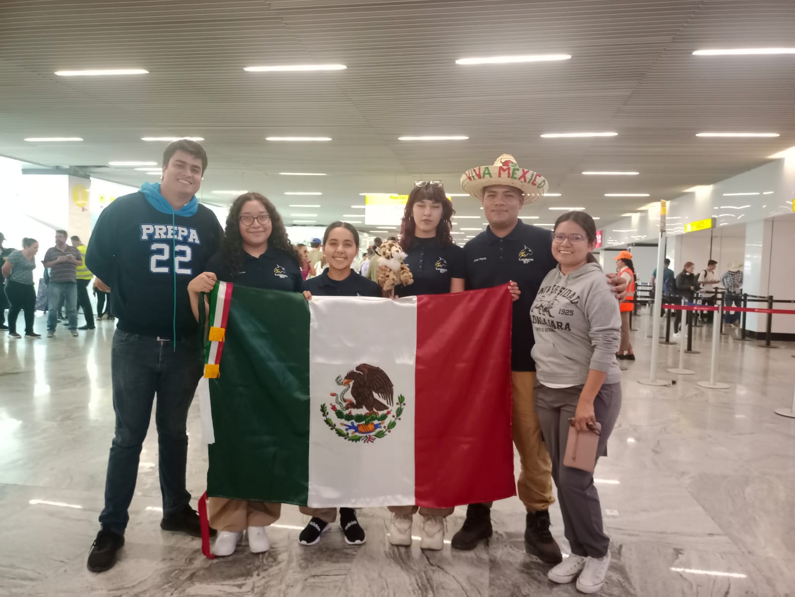 Integrantes de la escudería Tlaqueracing con bandera mexicana