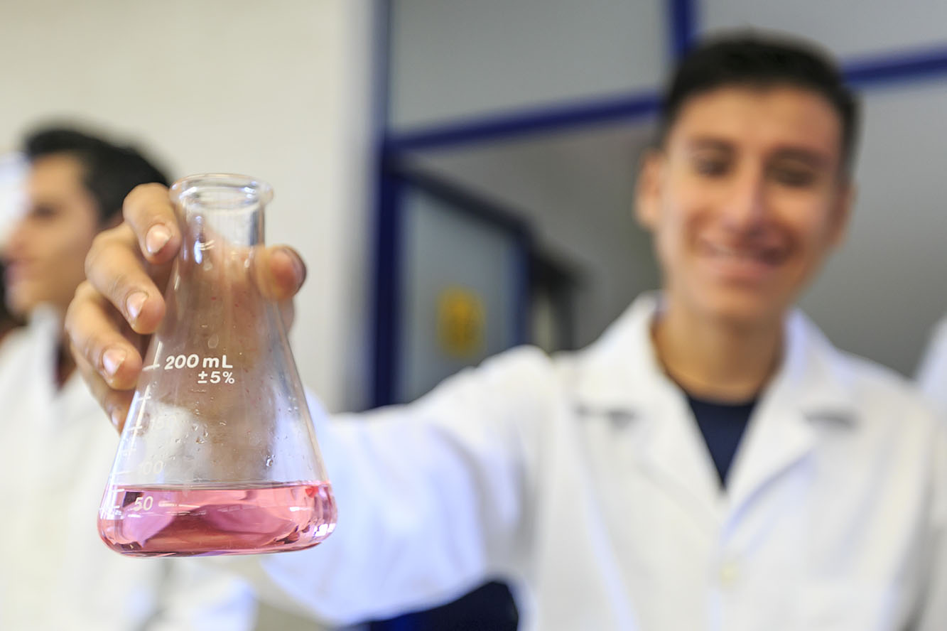 Alumno experimentando con un matraz