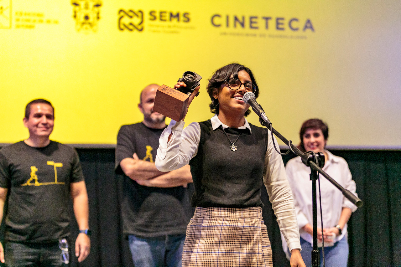 Ganadora de una categoría del evento con su estatuilla en las manos en uso de la voz