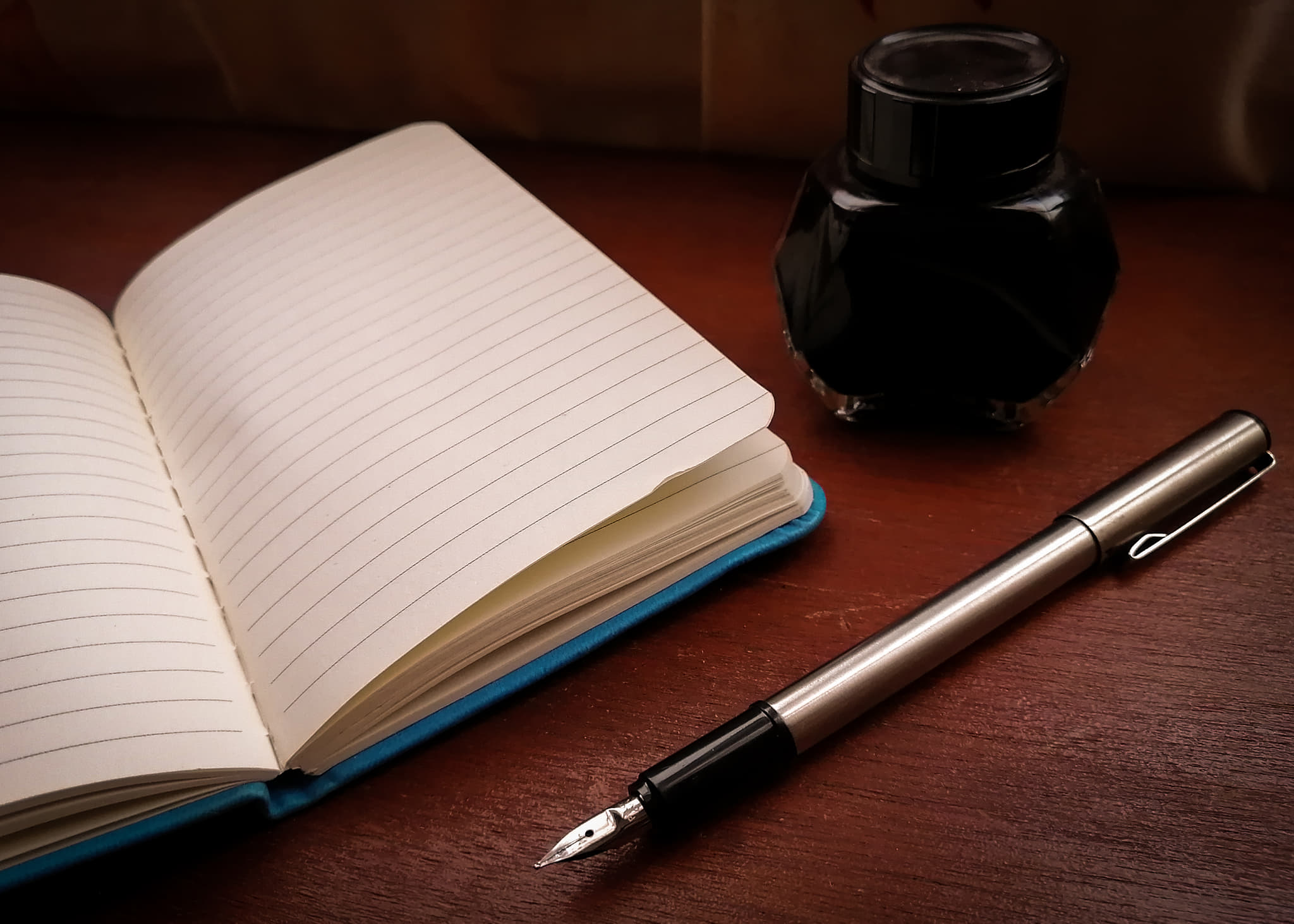 Libreta pluma y tinta sobre un escritorio