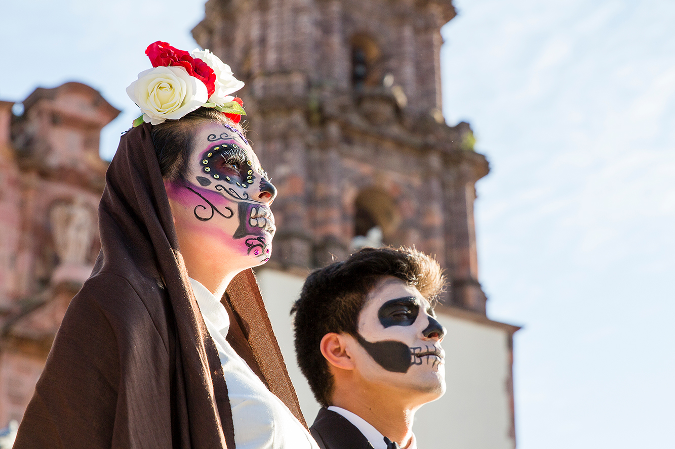 Mujer caracterizada de catrina y hombre caracterizado de catrín