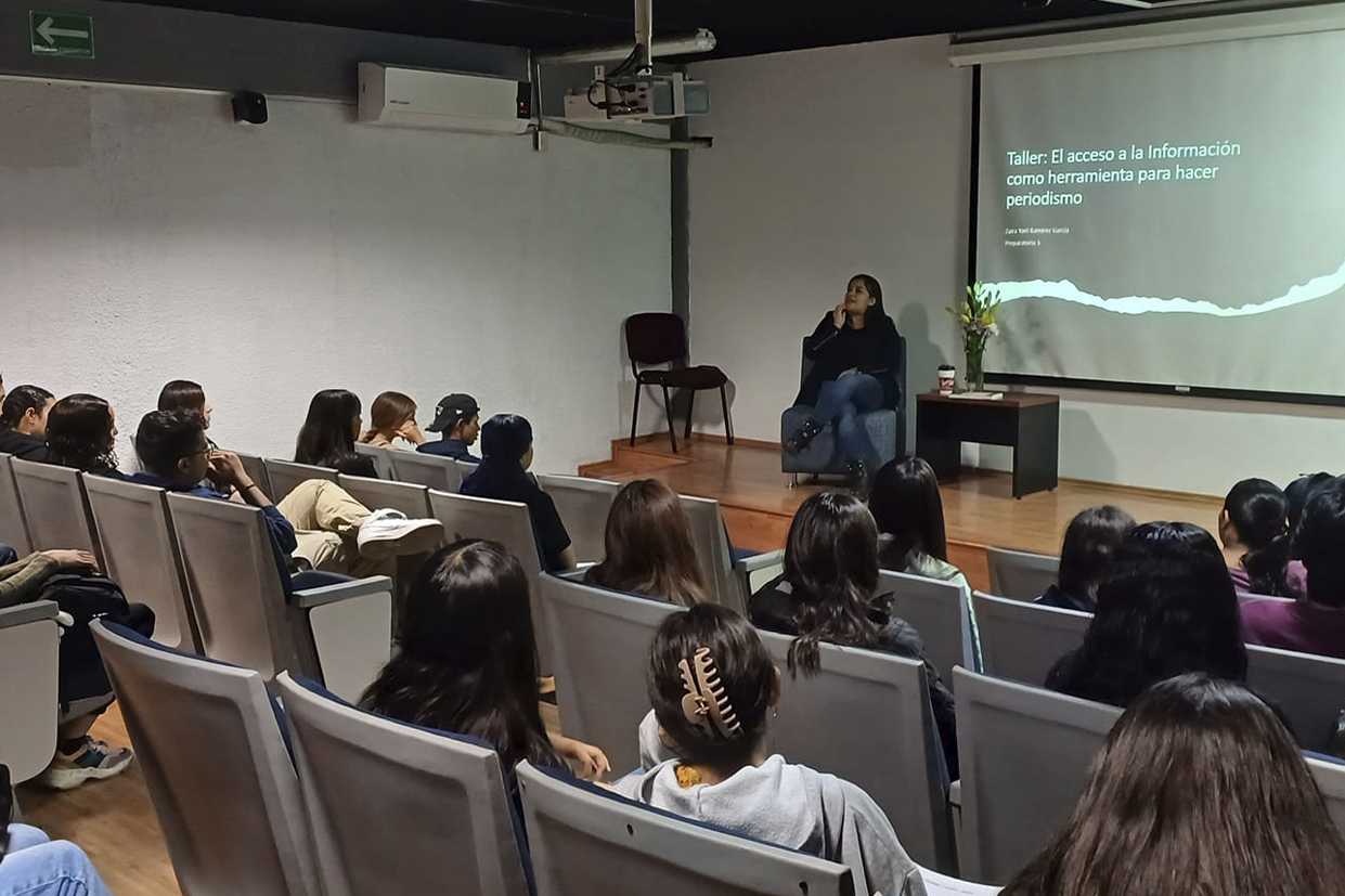 asistentes al evento sentados en auditorio