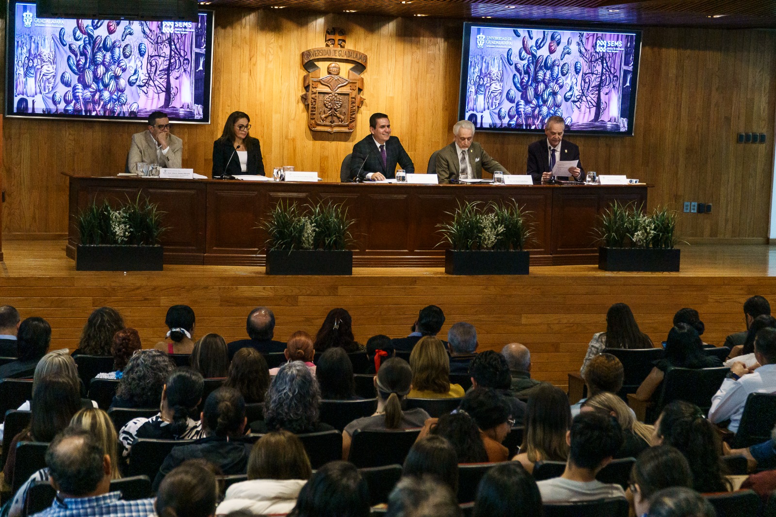 Autoridades del evento en presidium frente a asistentes en auditorio