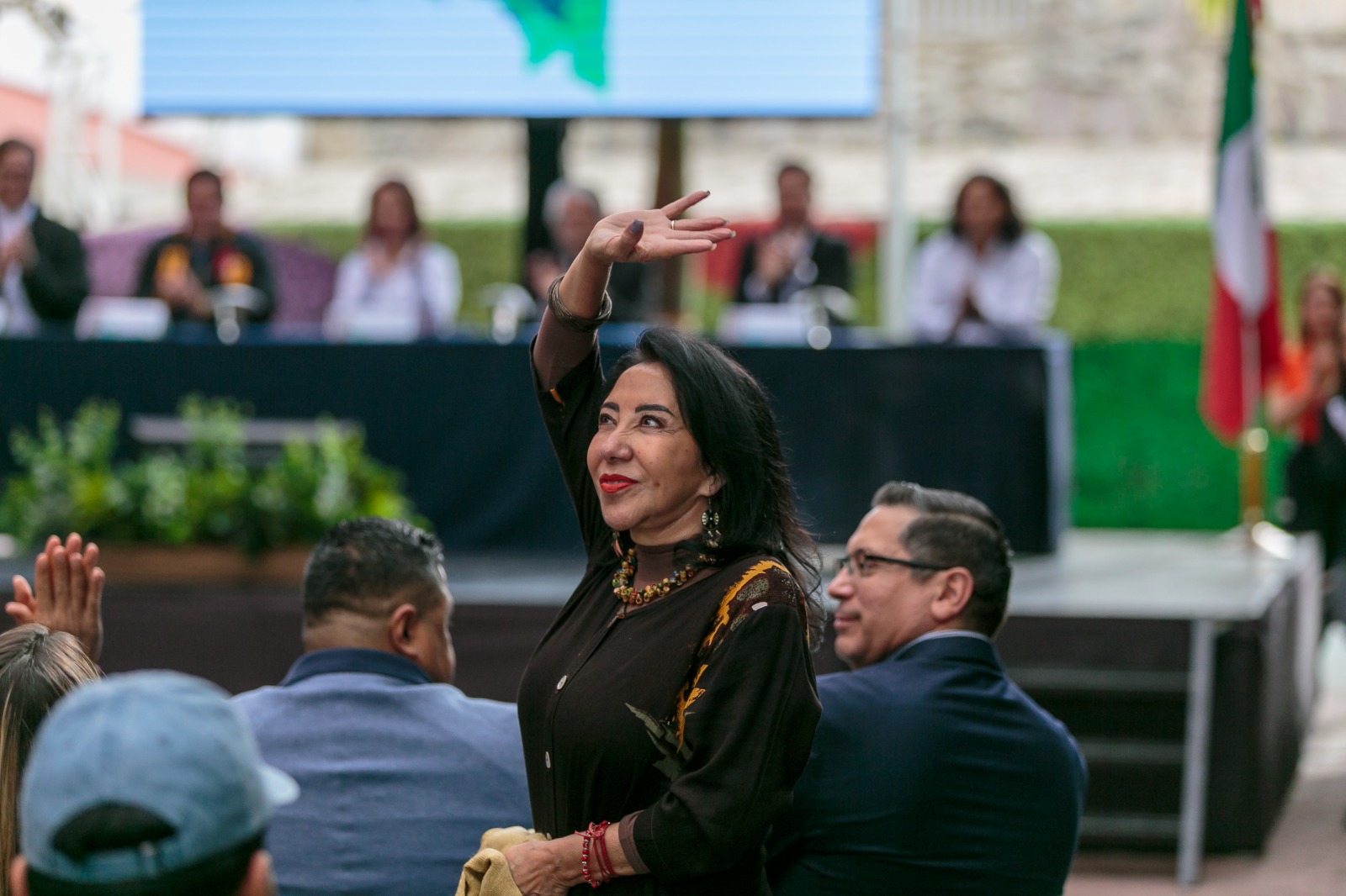 Autoridades del evento sentados en presidium frente a asistentes al evento sentados