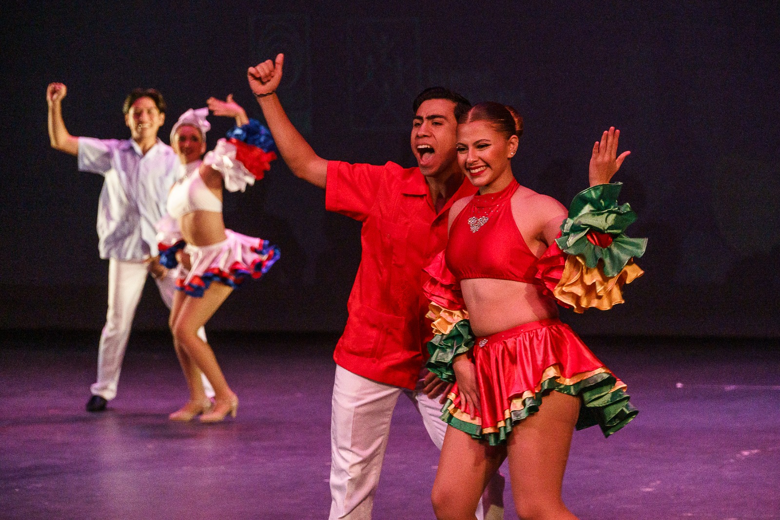 Integrantes de grupo de danza en escenario bailando