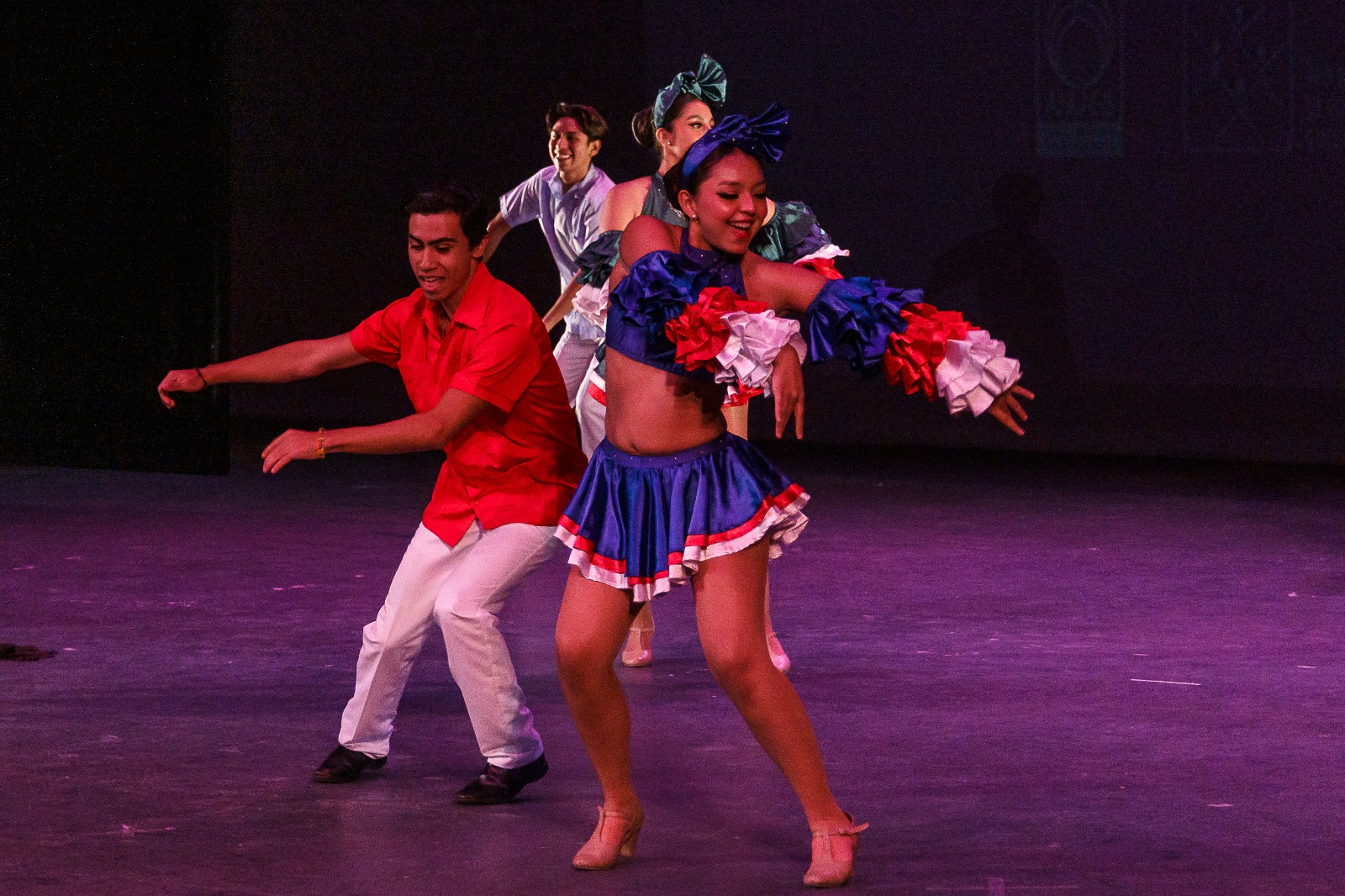 Integrantes de grupo de danza en escenario bailando