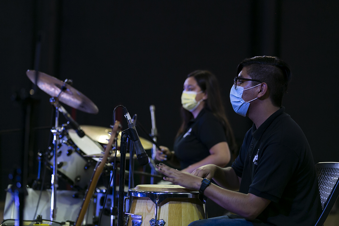 Jóvenes tocan bateria en el escenario