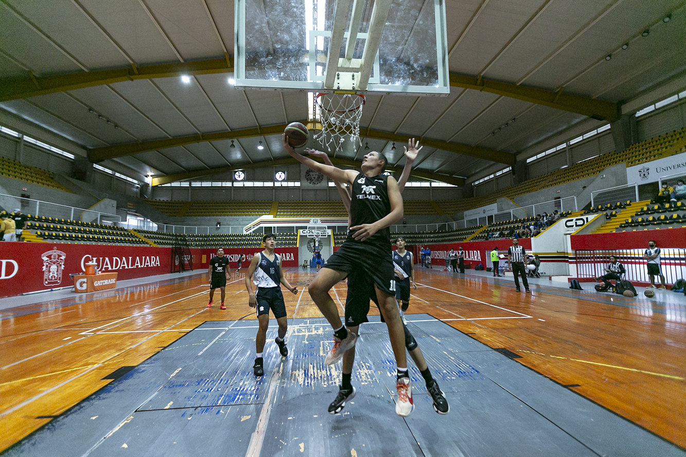 Jugadores participan en partido de basquetbol