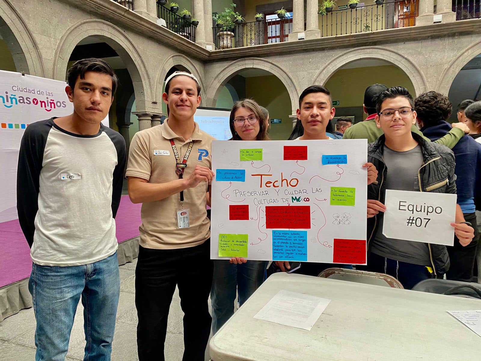 grupo de jóvenes sostienen pancarta en el evento