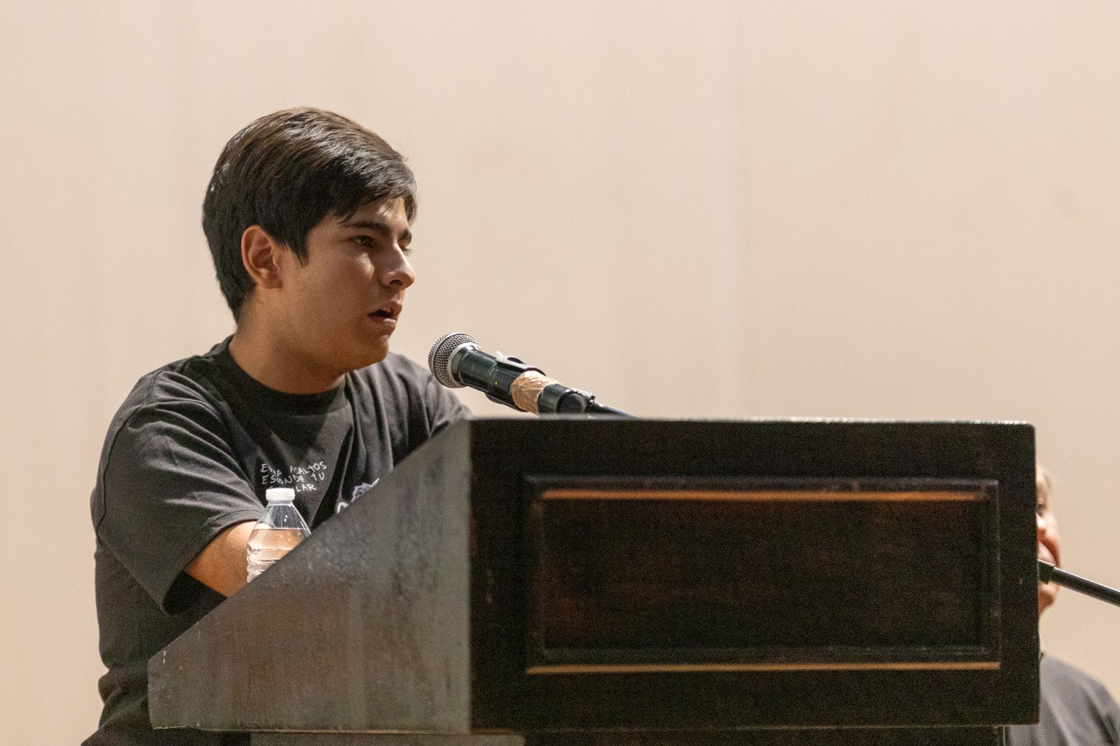 Jóven en uso de la voz en pódium