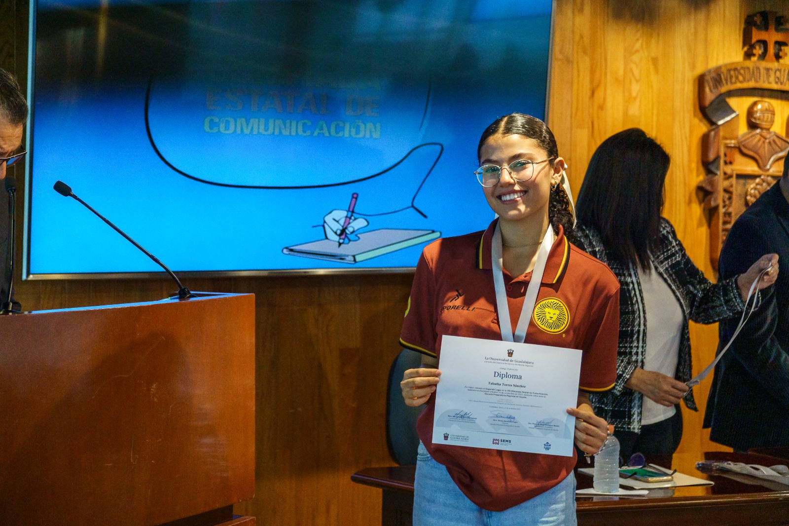 Alumna con su medalla y diploma que la acredita como ganadora de concurso