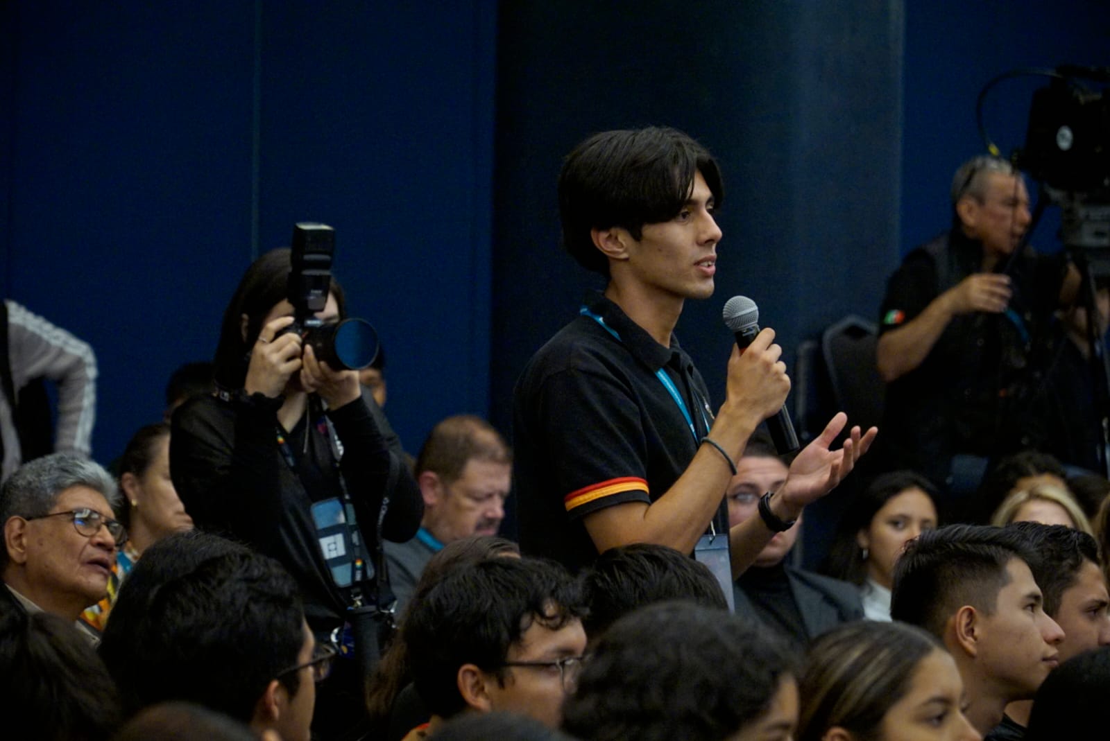 asistentes al evento sentados en auditorio