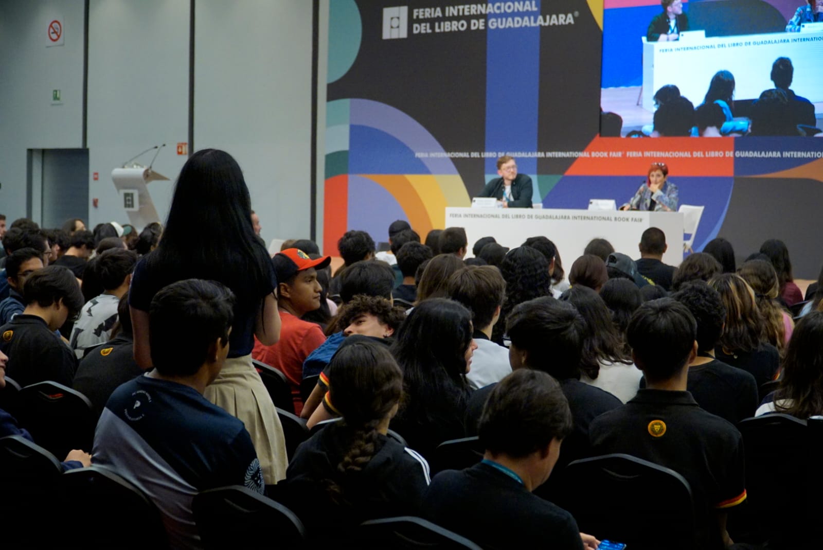 asistentes al evento sentados en auditorio