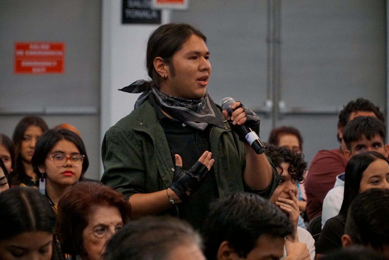 asistentes al evento sentados en auditorio