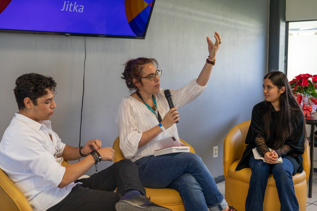 Escritora frente a asistentes en auditorio