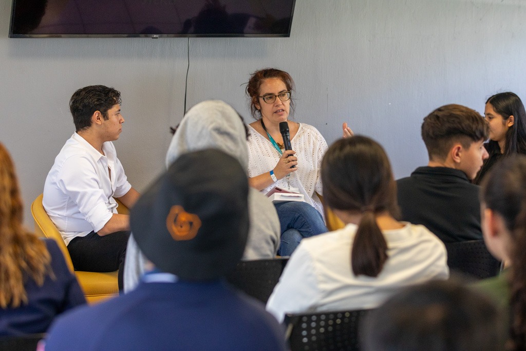 Escritora frente a asistentes en auditorio