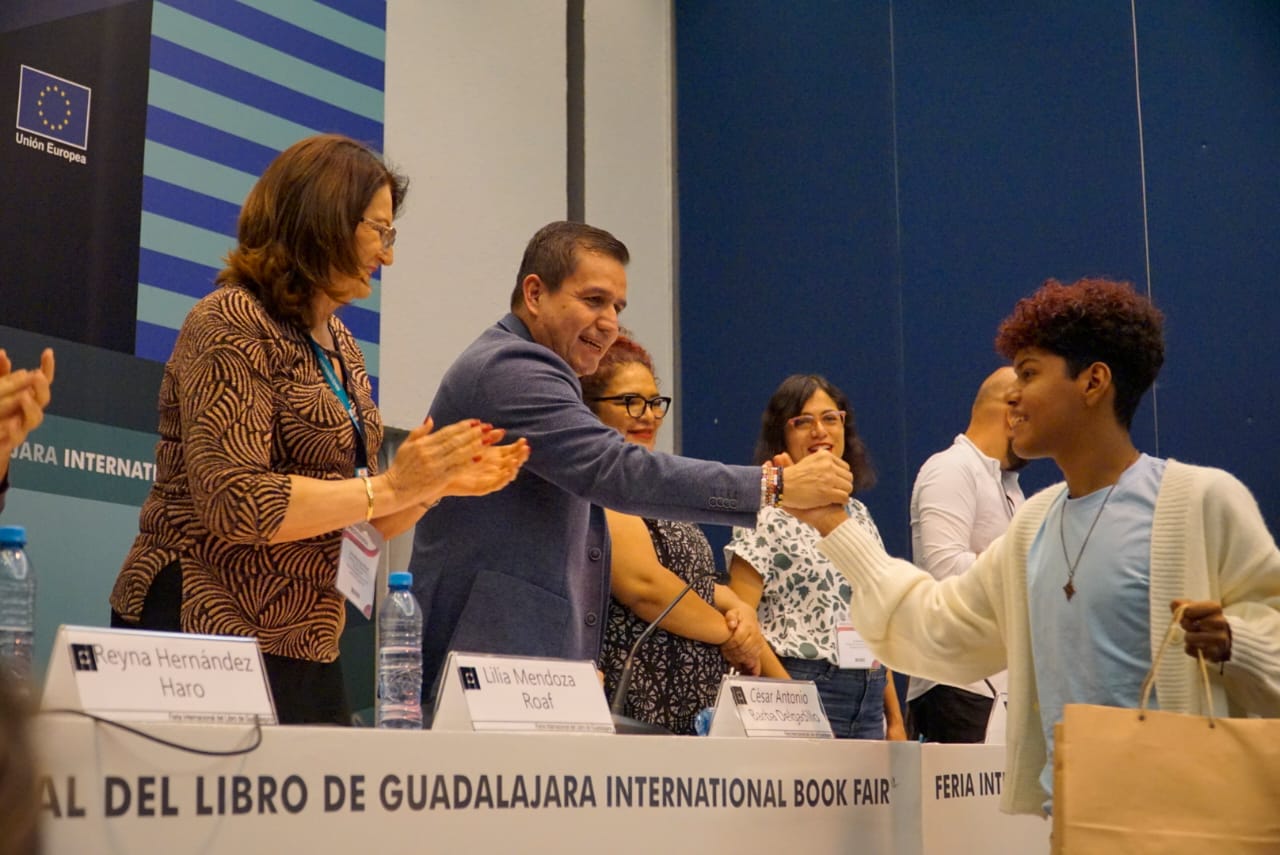 Autoridades del evento en presidium frente a asistentes en auditorio