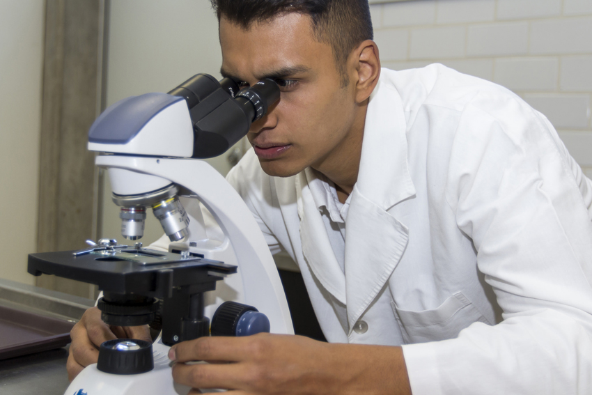 Alumno en uso de microscopio