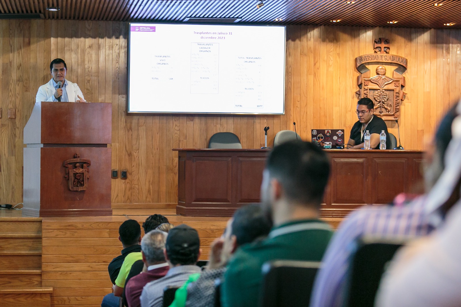 asistentes al evento sentados en auditorio