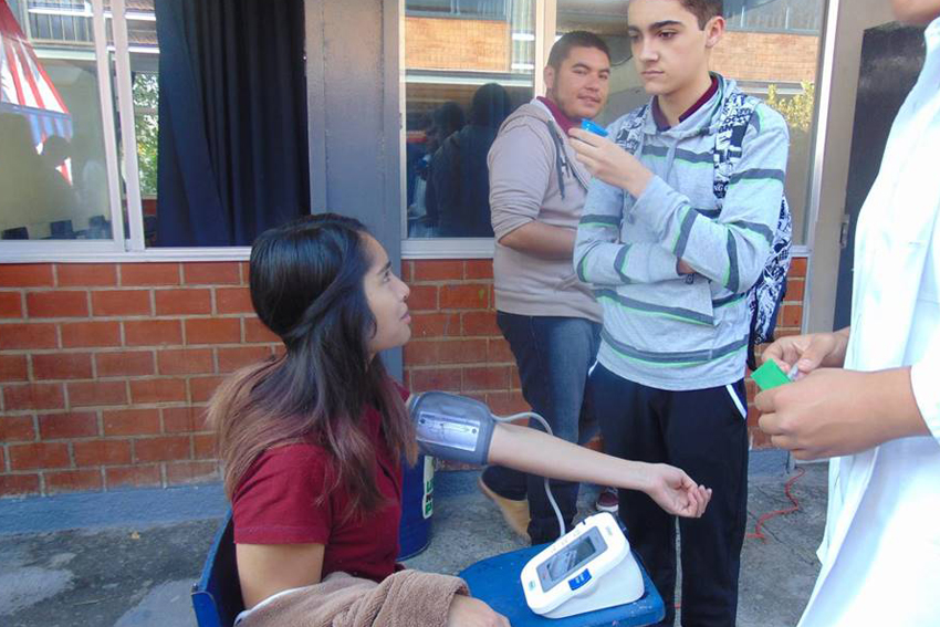 Alumna con aparato de toma de presión arterial