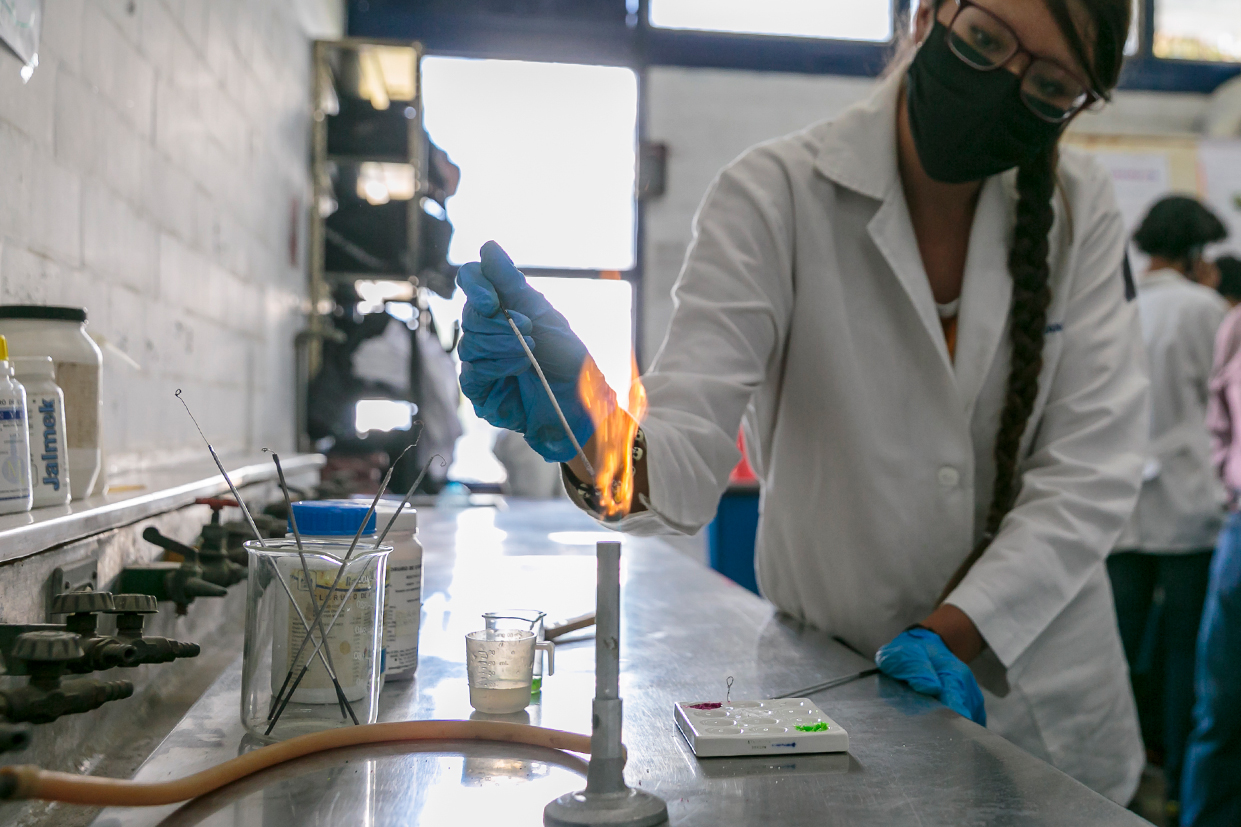 Mujer utiliza mechero de laboratorio