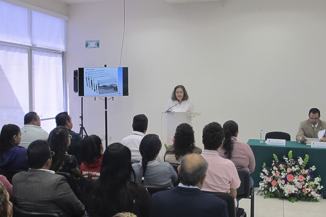 Directora en pódium frente a los asistentes al evento