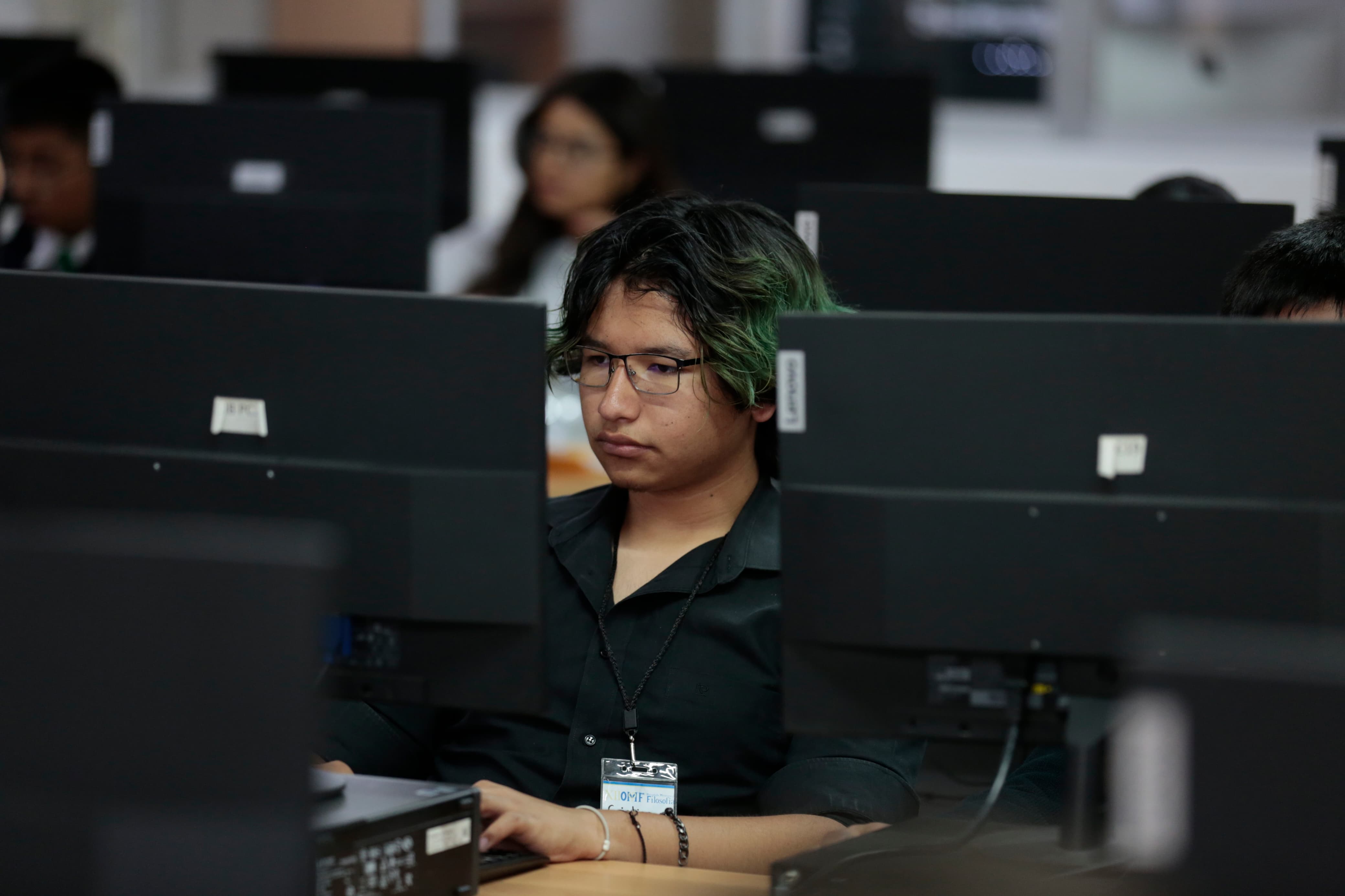 Participantes del evento sentados usando computadora
