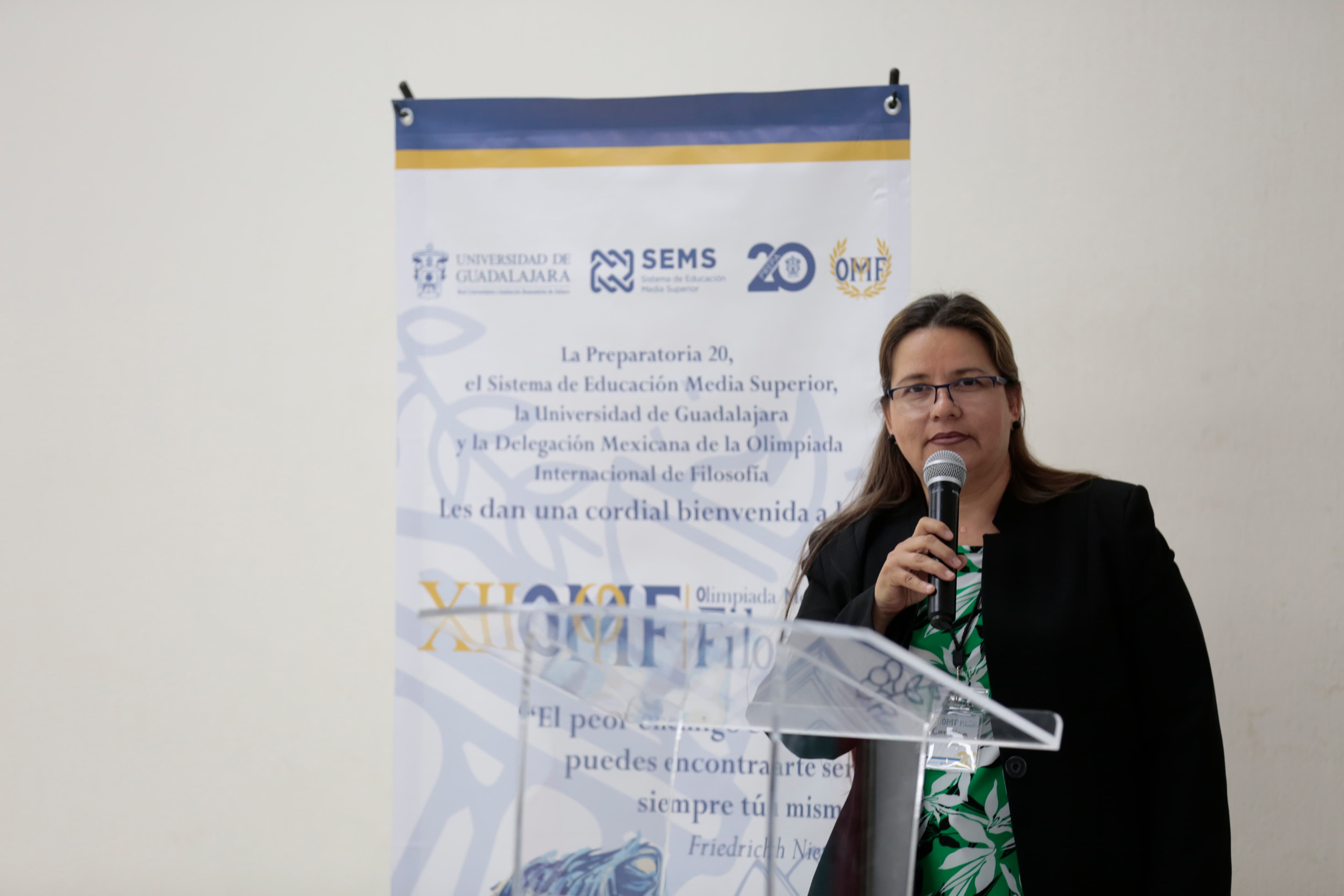 Autoridades del evento de pie en pódium en uso de la voz