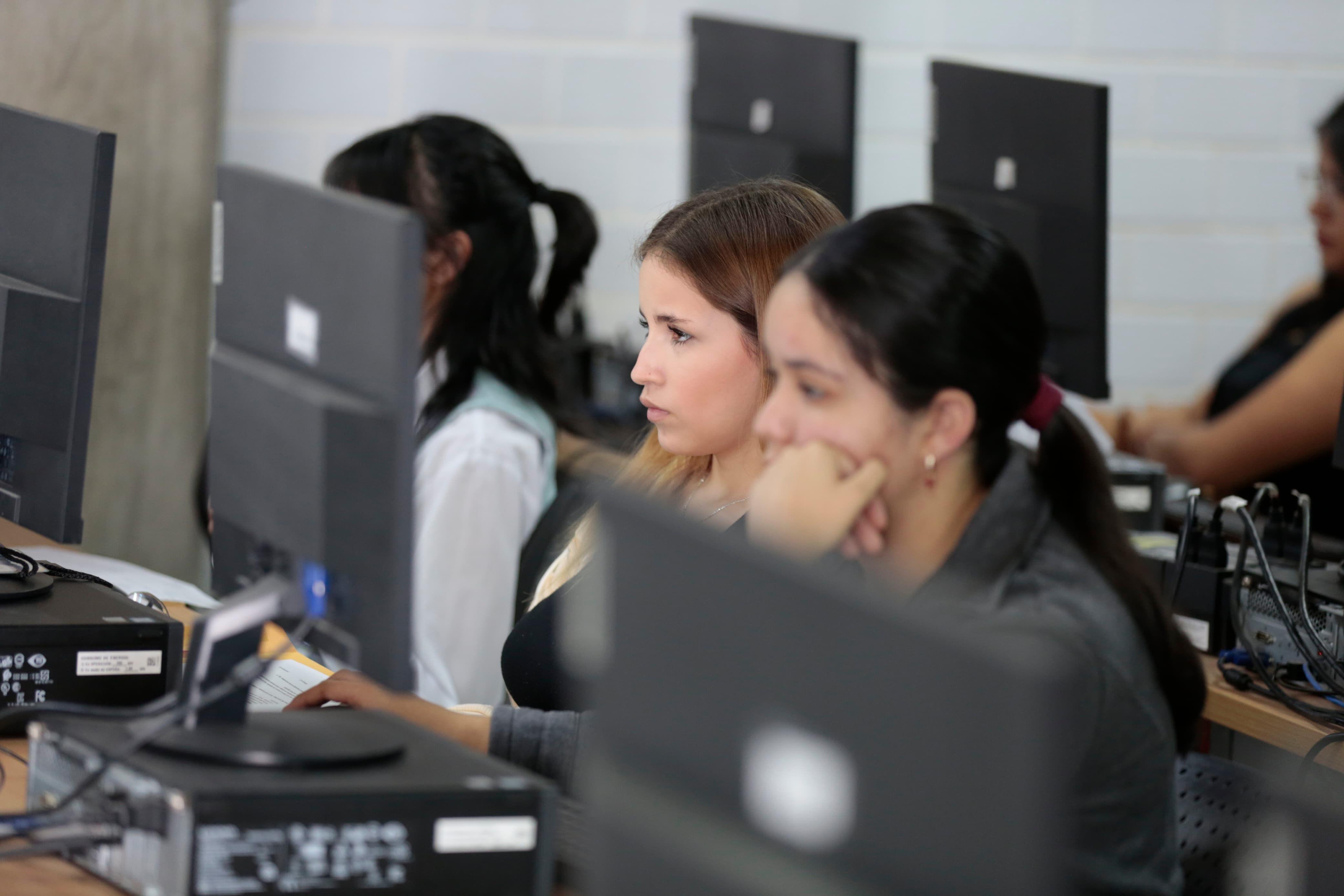 Participantes del evento sentados usando computadora