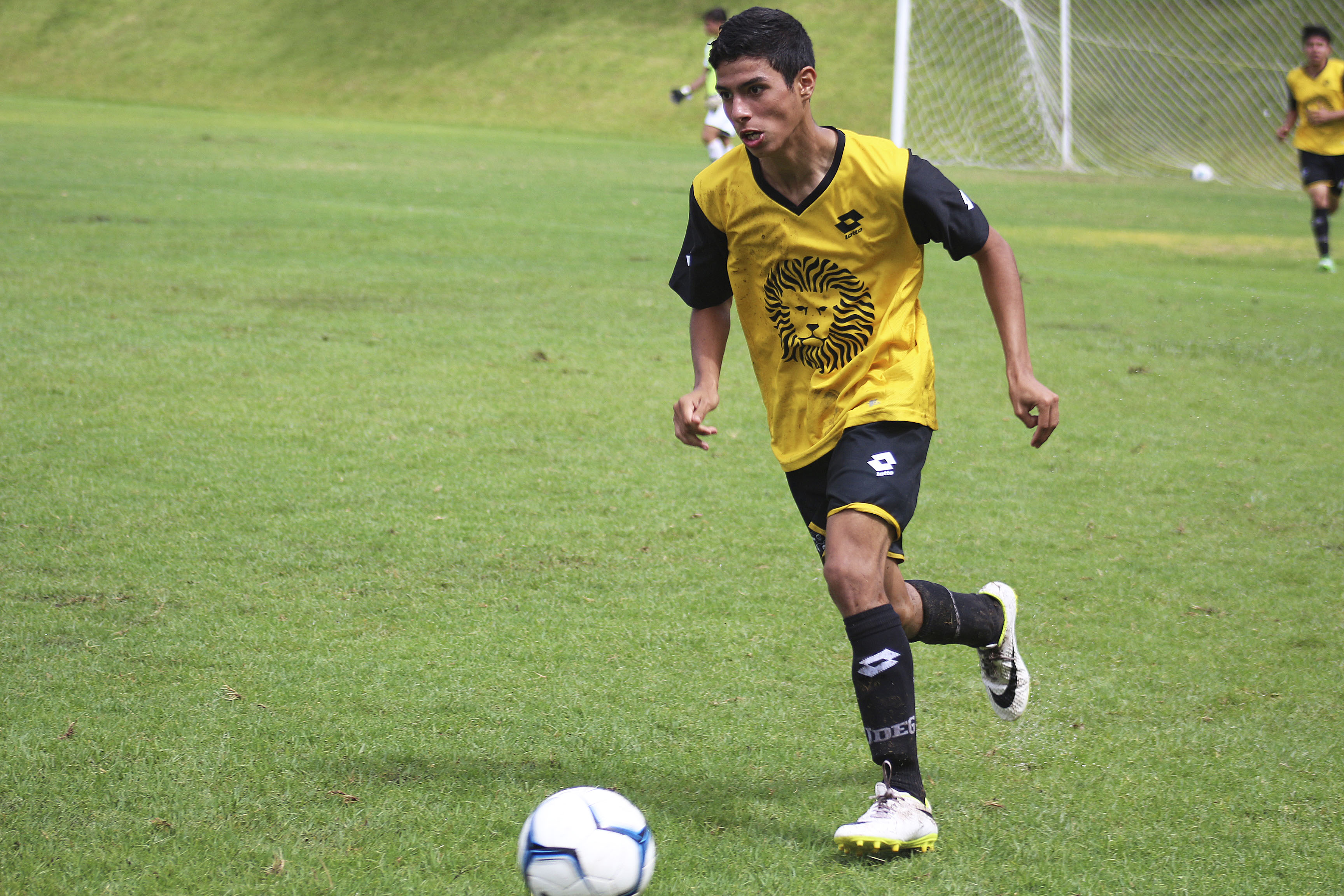 Alumno corriendo en partido de futbol