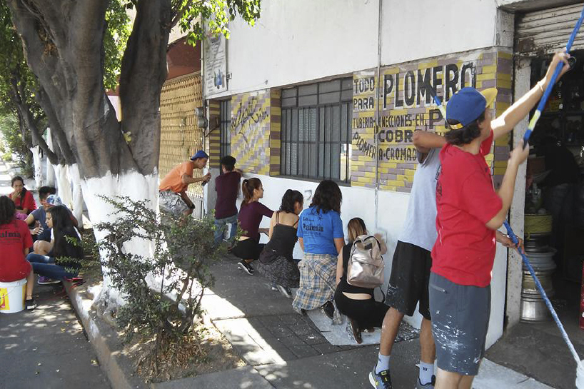 Alumnos pintan muro de local