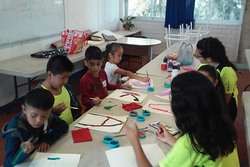 Niños en mesa de trabajo con instructoras